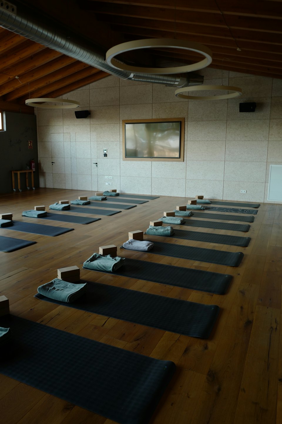 Yogastudio mit ordentlich arrangierten Matten, Blöcken und Handtüchern.