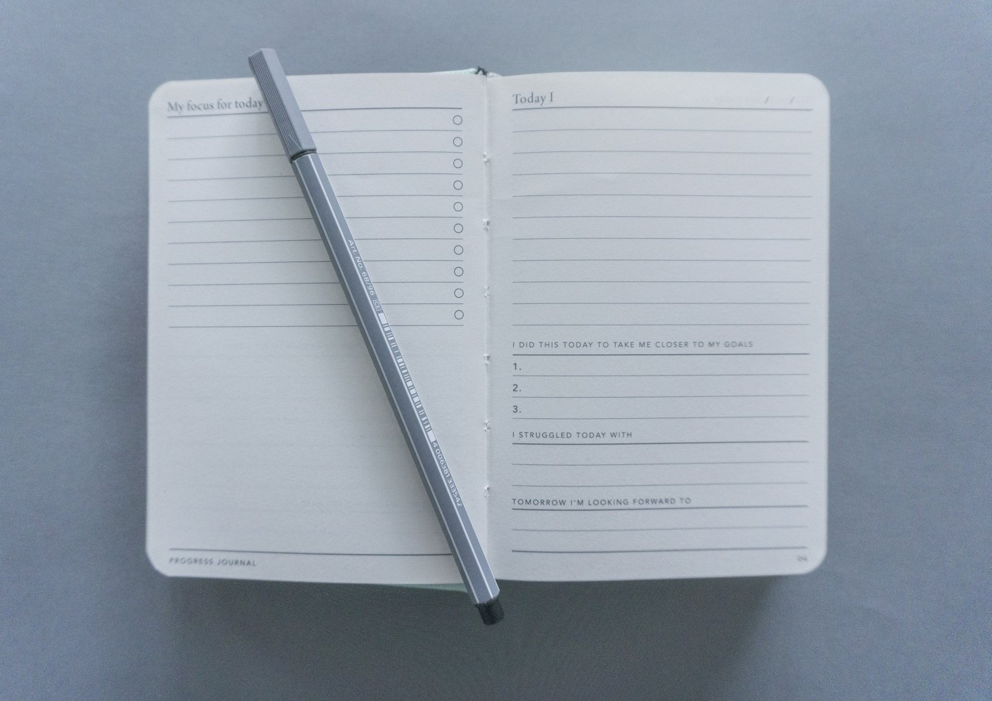 Offenes Notizbuch mit Planungsfragen und einem Stift.
